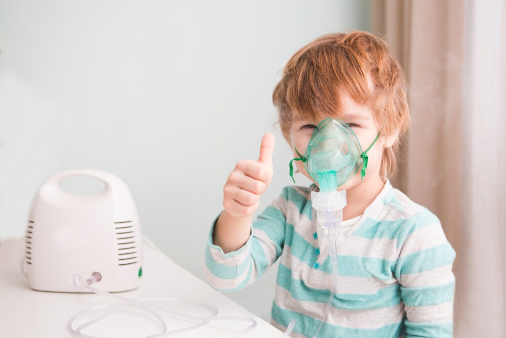 A child is inhaling oxygen with a portable nebulizer
